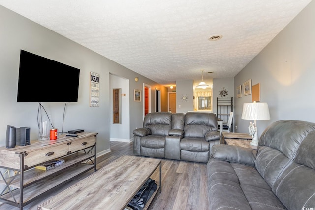 living room with wood-type flooring and a textured ceiling