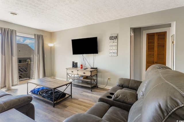 living room featuring wood-type flooring and a textured ceiling