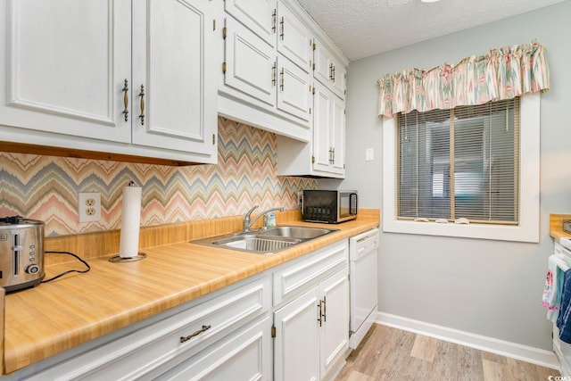 kitchen featuring dishwasher, tasteful backsplash, white cabinetry, sink, and light wood-type flooring