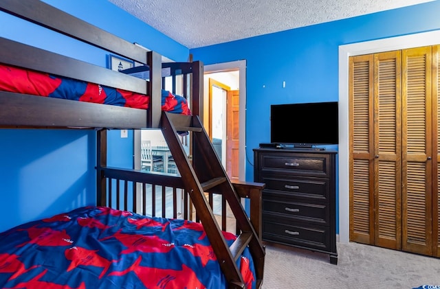 carpeted bedroom with a closet and a textured ceiling