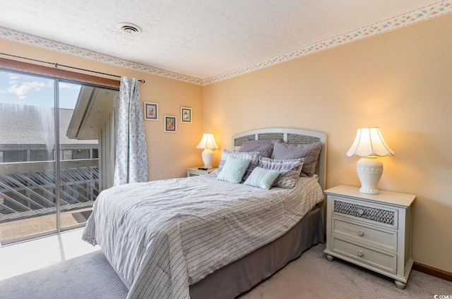 carpeted bedroom with a textured ceiling and access to exterior