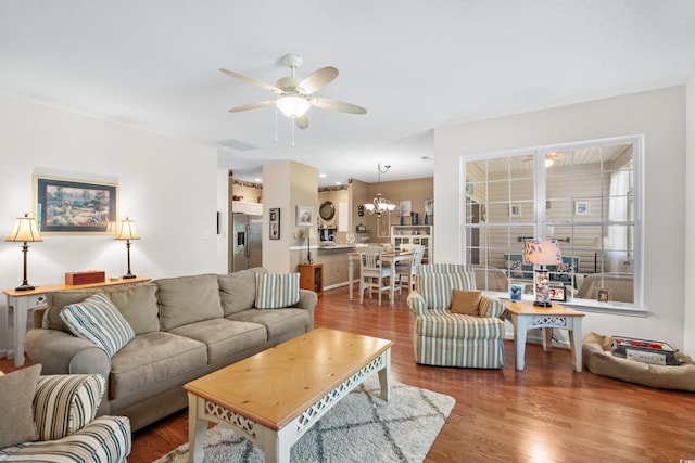 living room with wood-type flooring and ceiling fan with notable chandelier