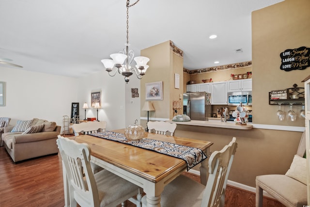 dining space featuring an inviting chandelier and dark hardwood / wood-style flooring