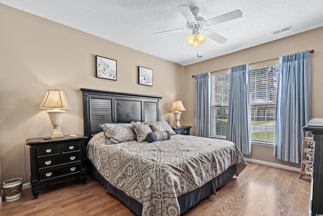 bedroom featuring a textured ceiling, ceiling fan, and hardwood / wood-style floors