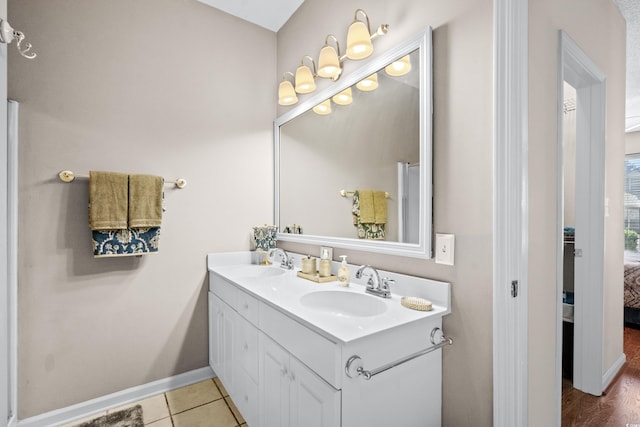 bathroom featuring wood-type flooring, vanity with extensive cabinet space, and dual sinks