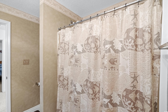 bathroom with crown molding and a textured ceiling