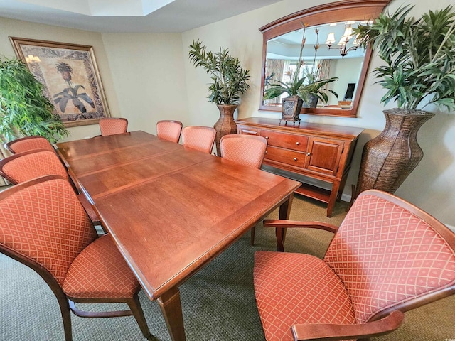 carpeted dining space featuring an inviting chandelier