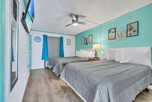 bedroom featuring crown molding, a textured ceiling, ceiling fan, and hardwood / wood-style floors