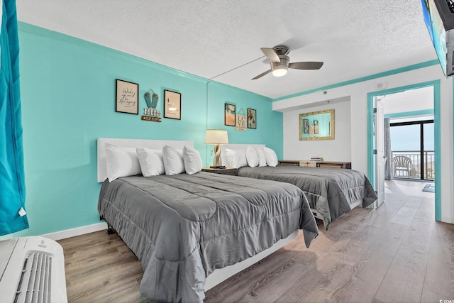 bedroom with hardwood / wood-style floors, ceiling fan, access to exterior, and a textured ceiling