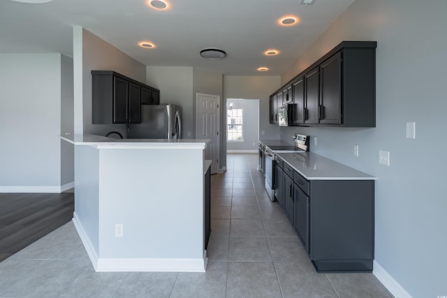 kitchen with light hardwood / wood-style flooring, kitchen peninsula, range with electric cooktop, and stainless steel fridge