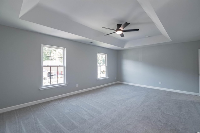 unfurnished room featuring carpet, ceiling fan, and a raised ceiling