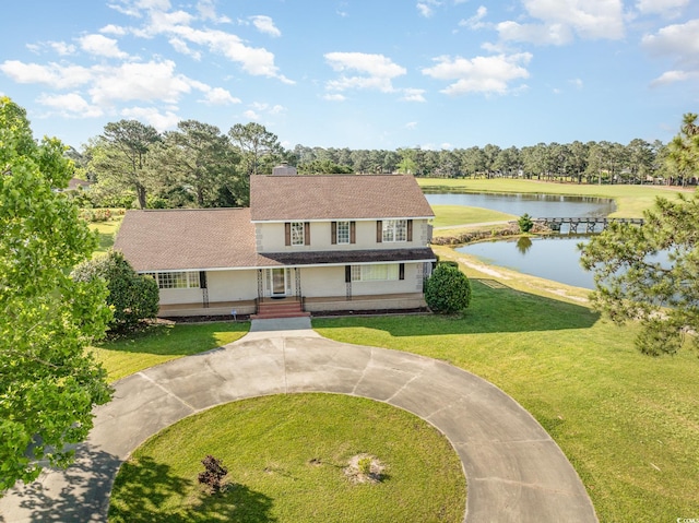 view of front of house with a water view and a front lawn