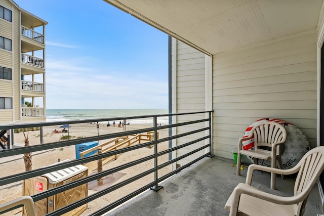 balcony featuring a water view and a view of the beach