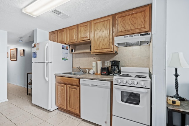 kitchen featuring tasteful backsplash, a textured ceiling, light tile patterned flooring, sink, and white appliances