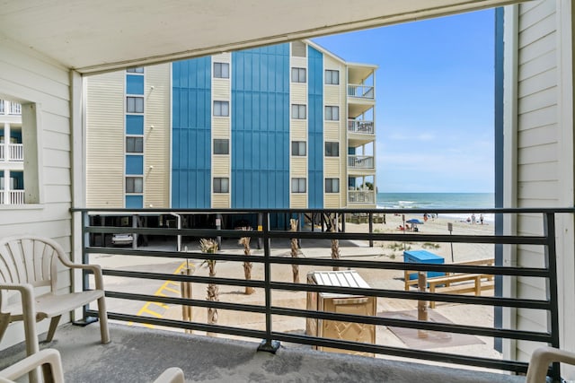 balcony featuring a water view and a view of the beach