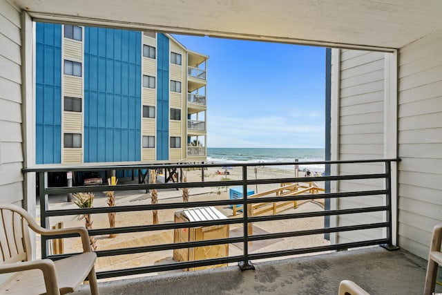 balcony featuring a water view and a view of the beach