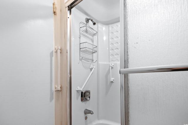 bathroom featuring combined bath / shower with glass door