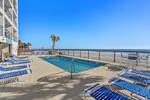 view of pool with a water view and a patio