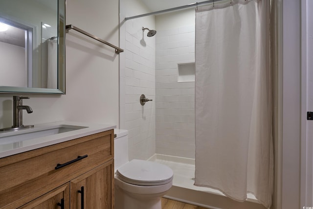 full bathroom with tiled shower / bath combo, wood-type flooring, toilet, and vanity