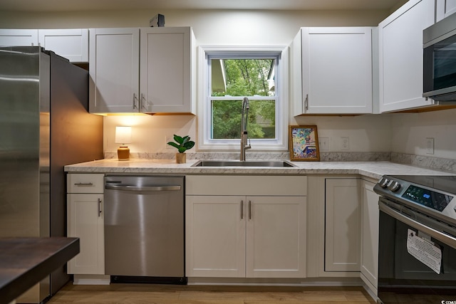 washroom with stacked washer and clothes dryer and light hardwood / wood-style flooring