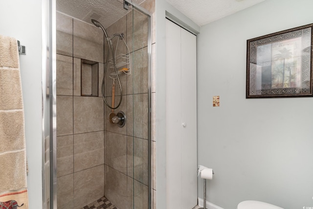 bathroom featuring a shower with shower door, toilet, and a textured ceiling