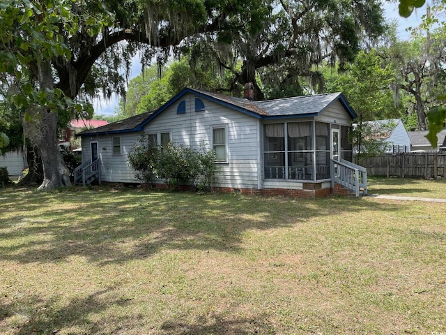 back of property featuring a yard and a sunroom