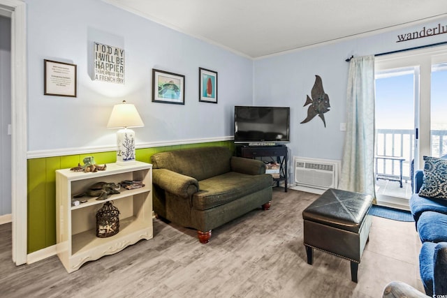 living room featuring an AC wall unit, hardwood / wood-style flooring, and ornamental molding