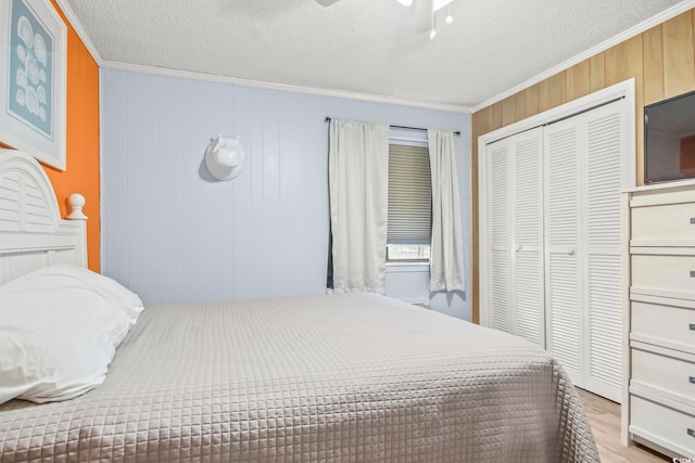 bedroom with a closet, crown molding, hardwood / wood-style flooring, ceiling fan, and a textured ceiling