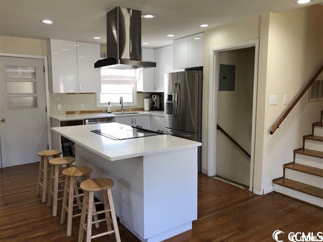 kitchen featuring a center island, extractor fan, white cabinetry, stainless steel refrigerator with ice dispenser, and dark hardwood / wood-style flooring