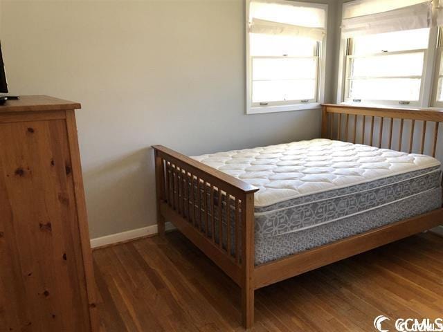 bedroom with dark hardwood / wood-style floors