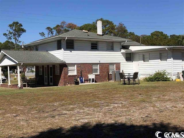 rear view of property featuring a lawn