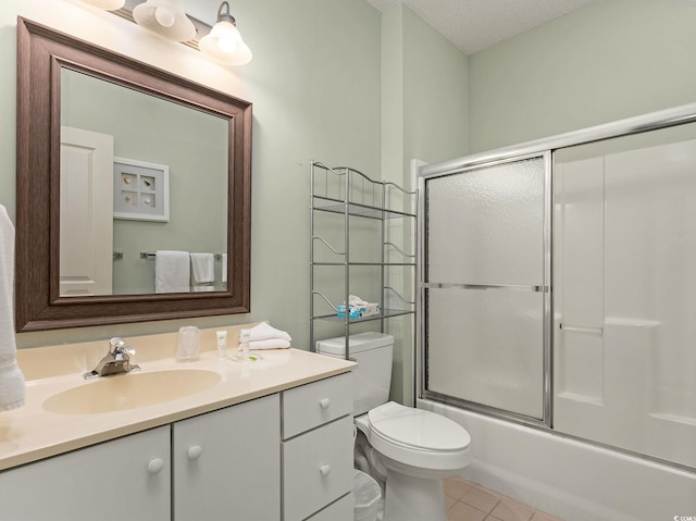 full bathroom featuring tile flooring, a textured ceiling, combined bath / shower with glass door, toilet, and vanity