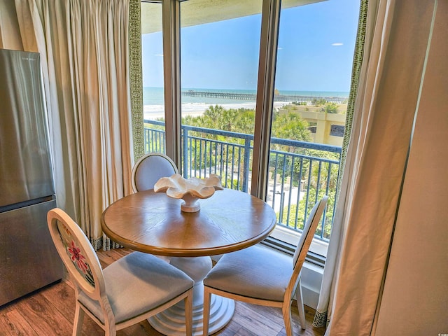 dining space with a water view and wood finished floors