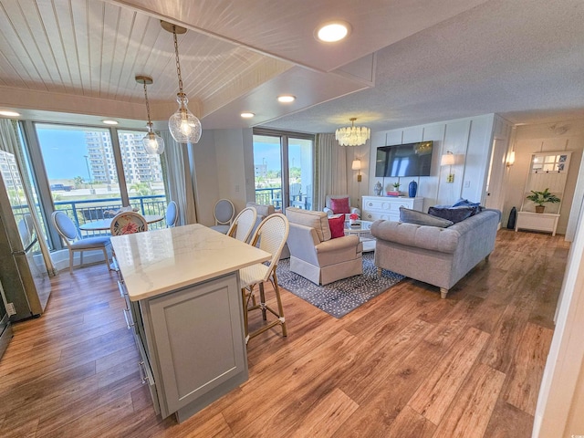 kitchen with open floor plan, a breakfast bar, a center island, gray cabinets, and light wood-type flooring