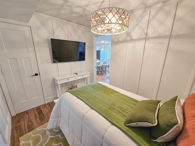 bedroom with a decorative wall and wood finished floors