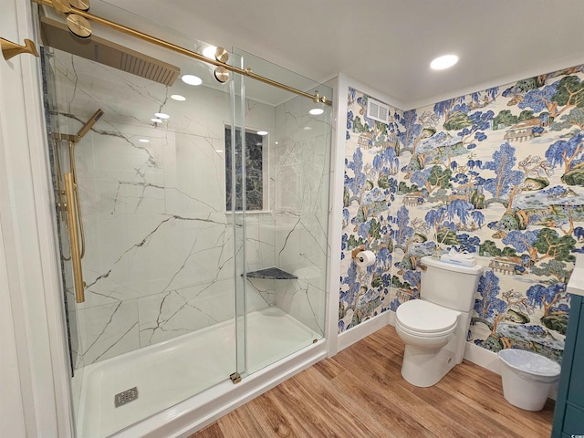 bathroom with a marble finish shower, wood finished floors, toilet, and baseboards