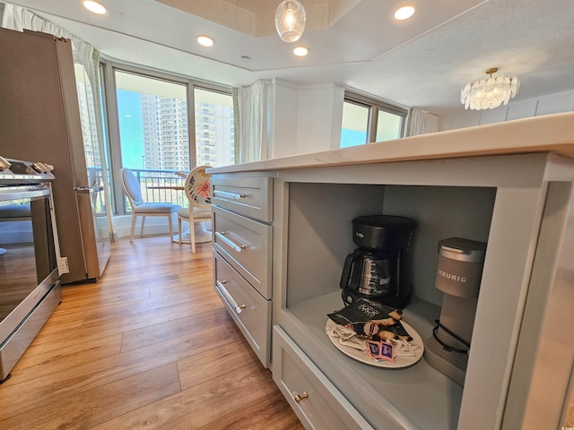 kitchen featuring recessed lighting, light countertops, light wood-style floors, stainless steel range oven, and a chandelier