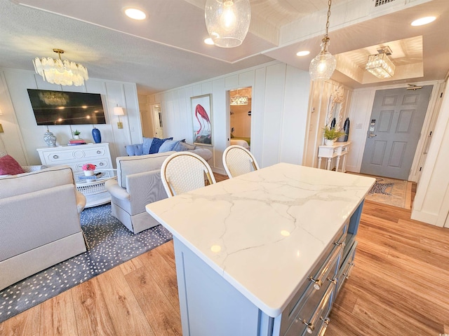 kitchen with a center island, a notable chandelier, light wood finished floors, hanging light fixtures, and open floor plan