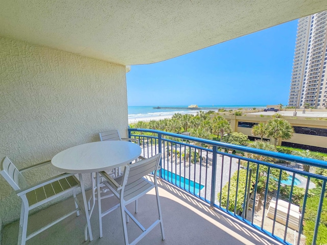 balcony featuring a water view and a beach view