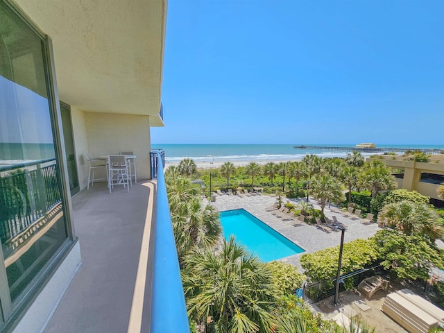 balcony with a water view and a beach view