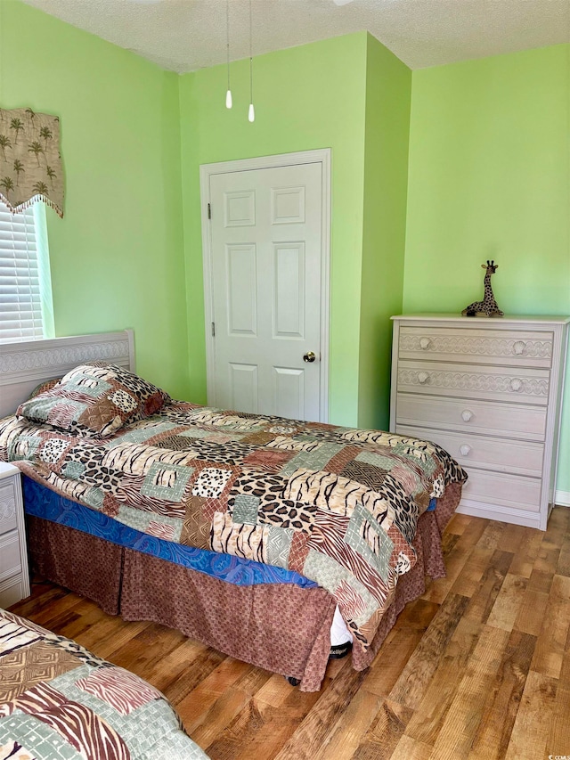 bedroom featuring wood-type flooring and a textured ceiling