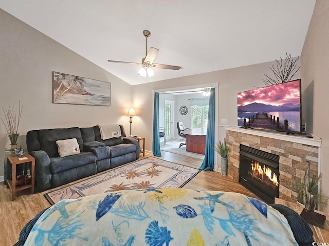 living room featuring a fireplace, ceiling fan, light hardwood / wood-style flooring, and vaulted ceiling