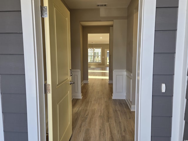 corridor with hardwood / wood-style flooring