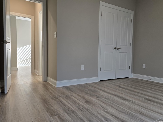 unfurnished bedroom with light hardwood / wood-style floors and a closet