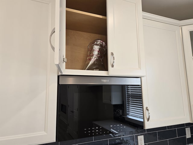 interior details featuring decorative backsplash and white cabinetry