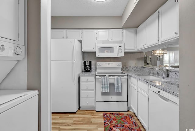 kitchen with white cabinets, white appliances, backsplash, sink, and light hardwood / wood-style floors