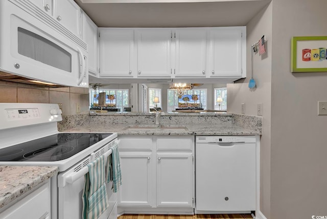 kitchen featuring light wood-type flooring, sink, white appliances, and white cabinetry