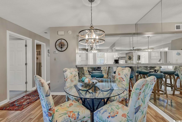 dining area with an inviting chandelier and light wood-type flooring