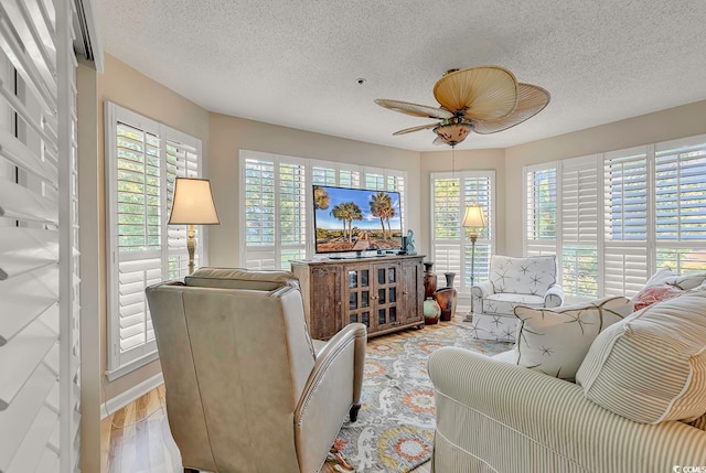 living room featuring a textured ceiling, a wealth of natural light, and light hardwood / wood-style floors