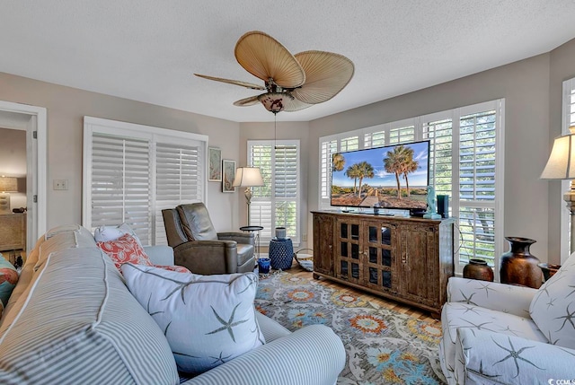 living room featuring a textured ceiling, ceiling fan, and hardwood / wood-style flooring